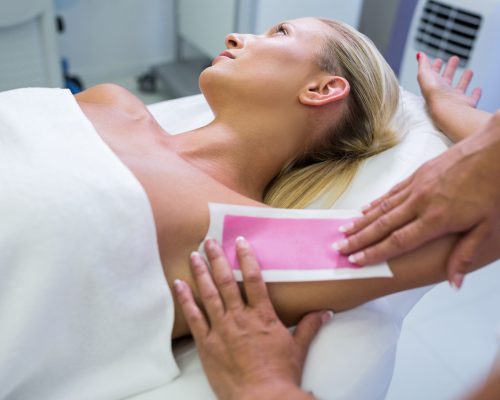 Woman getting her armpit hair removed at beauty salon
